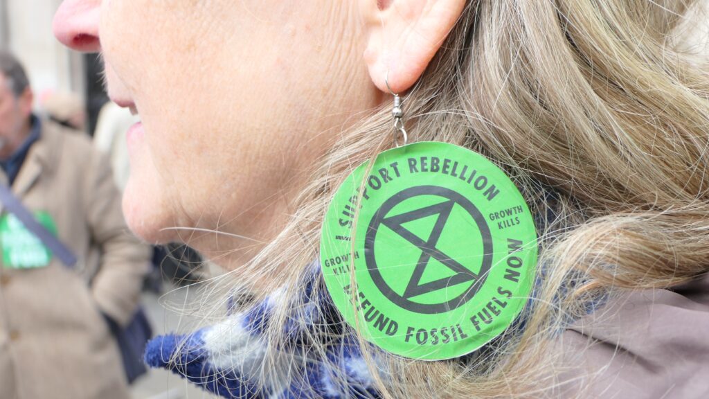 Jenny Condit sports XR earrings at a protest at the Royal Courts of Justice in London.